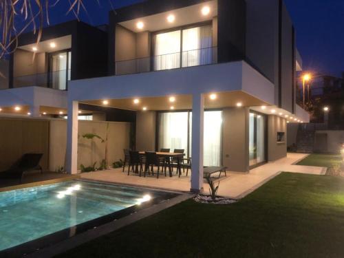 a house with a swimming pool in front of it at Çeşme merkez 4 oda odalarbanyolu in Cesme