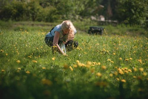 a woman kneeling in a field of flowers at Hotel La Romantica in Le Prese, Poschiavo