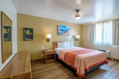 a hotel room with a bed and a mirror at Glenwood Springs Cedar Lodge in Glenwood Springs