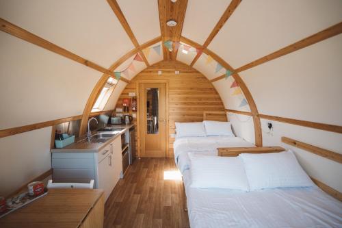 two beds in a small room with a kitchen at Sedgewell Barn by Wigwam Holidays in Northallerton