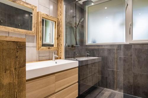 une salle de bain avec un lavabo et un miroir dans l'établissement Le BH 22, à La Bresse