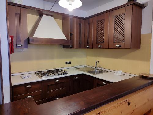 a kitchen with wooden cabinets and a stove top oven at Matese Home in San Massimo