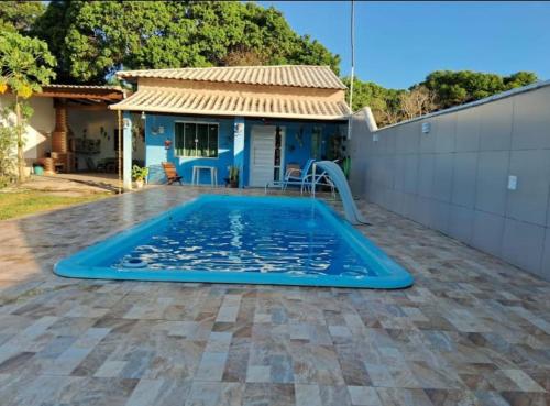 a large blue swimming pool in front of a house at Casa em Unamar com piscina privativa in Cabo Frio