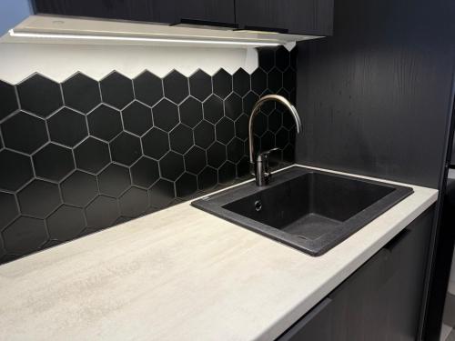 una cucina con un lavandino nero e una parete nera di La Casa De Kotka a Kotka