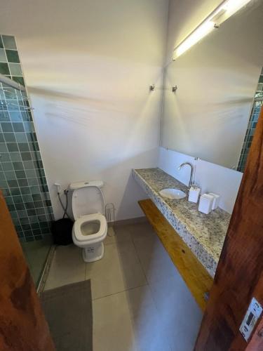 a bathroom with a toilet and a sink at Casa Umbuê 01 - Vista Mar in Cayru