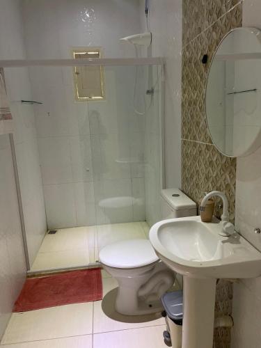 a bathroom with a toilet and a sink at Chácara Lara Bela in Praia do Saco
