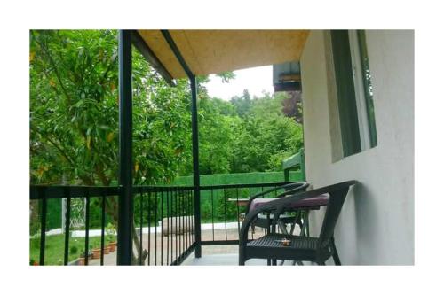 a balcony with two black chairs and a table at BANI tsikhisdziri in Tsikhisdziri