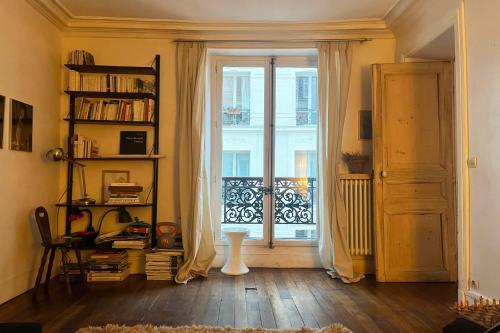 Cette chambre dispose d'une grande fenêtre et d'une porte. dans l'établissement Charming spacious T2 in the 18th - Paris, à Paris