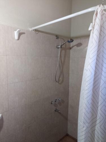 a shower with a shower curtain in a bathroom at El Paraíso in San Rafael