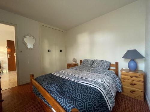 - une chambre avec un lit et une lampe bleue sur une commode dans l'établissement Argelès T2 proche plage avec parking et patio - FR-1-309-489, à Argelès-sur-Mer