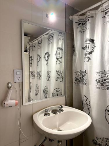 a bathroom with a sink and a mirror at Hotel Miami in San Miguel de Tucumán