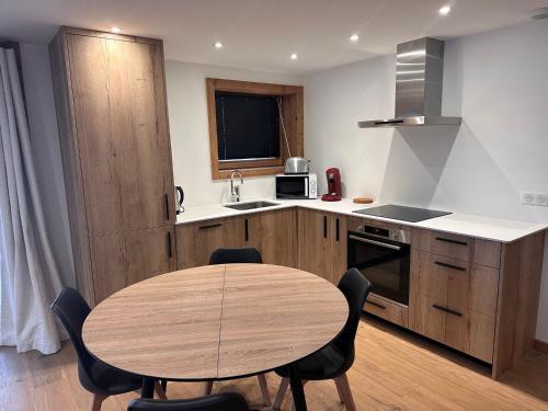 une cuisine avec une table et des chaises dans une pièce dans l'établissement Appartement cozy 3P à 5m du front de neige avec parking et terrasse - FR-1-464-236, à Pralognan-la-Vanoise