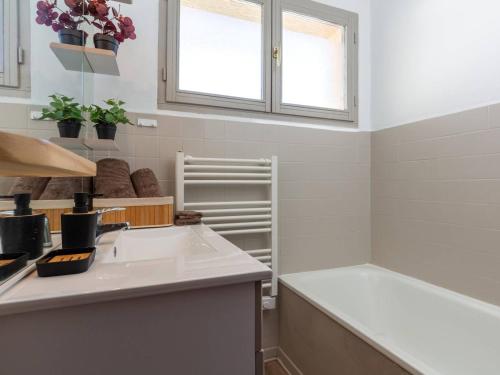 une cuisine blanche avec un évier et une fenêtre dans l'établissement Grand Appart 13 pers. au pied des pistes à Saint-Lary-Soulan - FR-1-296-511, à Saint-Lary-Soulan