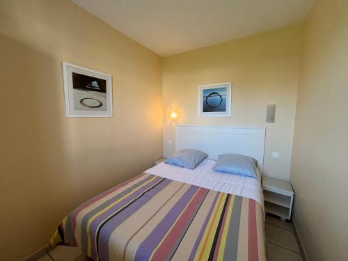 une petite chambre avec un lit avec deux oreillers dans l'établissement Appartement 2 chambres avec piscines chauffées et parking aux Sables-d'Olonne - FR-1-197-615, à Les Sables-dʼOlonne