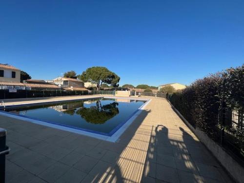 une piscine à l'ombre d'un bâtiment dans l'établissement T2 Cabine RdC - Près Plages, Animaux Bienvenus - FR-1-749-81, au Cap d'Agde
