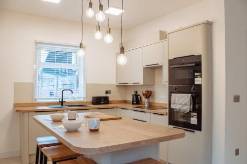 a kitchen with a wooden table and a counter top at Spacious 13-Bed in the Heart of Headingley in Headingley