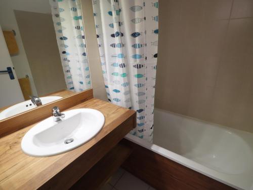 une salle de bain avec un lavabo et une baignoire dans l'établissement T2 avec WIFI, 1ère ligne mer, terrasse, parking - FR-1-472A-310, à Sète