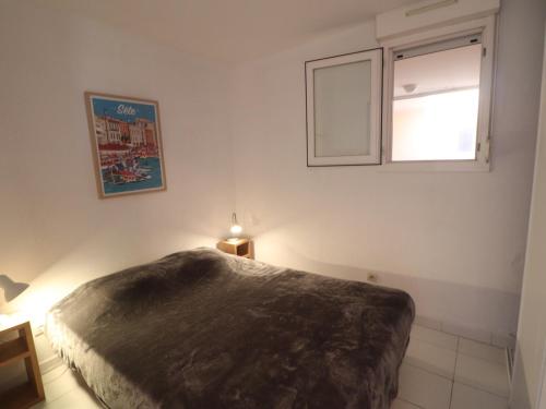 une chambre avec un grand lit et une fenêtre dans l'établissement T2 avec WIFI, 1ère ligne mer, terrasse, parking - FR-1-472A-310, à Sète