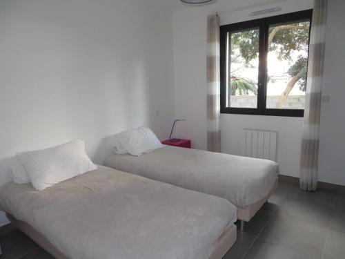 deux lits dans une chambre avec une fenêtre dans l'établissement Villa moderne 5 pièces avec WIFI, climatisation, et parkings à Sète - FR-1-338-597, à Sète