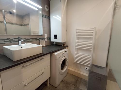 une salle de bain avec un lavabo et une machine à laver dans l'établissement T2 confortable à Sète avec climatisation et WIFI - FR-1-338-598, à Sète