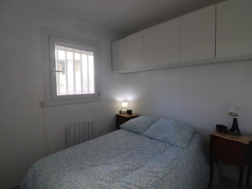 une petite chambre avec un lit et une fenêtre dans l'établissement Charmant T2 avec piscine et garage à Sète - FR-1-472A-313, à Sète