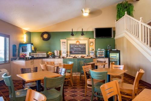 a restaurant with tables and chairs and a counter at AmericInn by Wyndham Okoboji in Okoboji