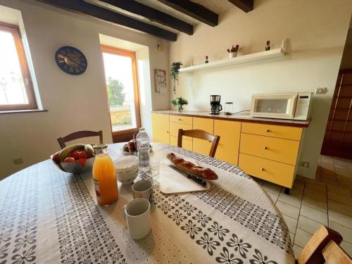 - une cuisine avec une table, de la nourriture et du jus d'orange dans l'établissement Gîte viticole tout inclus, jardin 3000m², vélos offerts, proche Saumur-Chinon-Langeais - FR-1-381-606, à Benais