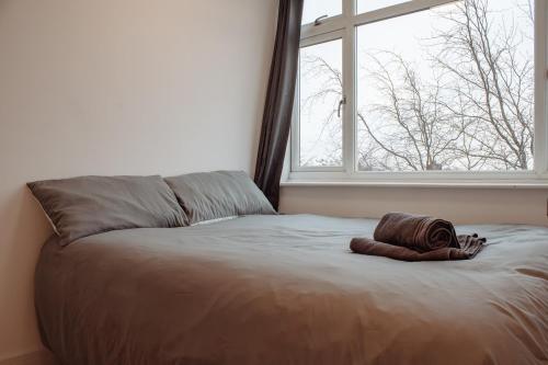 a bedroom with a bed with a blanket and a window at Spacious 13-Bed in the Heart of Headingley in Headingley