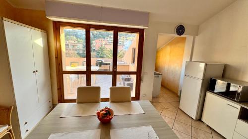 a kitchen with a table and a refrigerator at Appartamento Quadrifoglio in Castelsardo