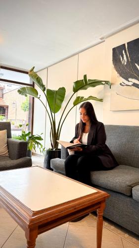 a woman sitting on a couch in a living room at Hotel Miami in San Miguel de Tucumán