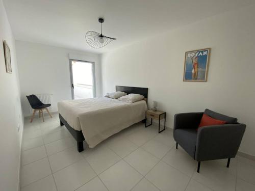 ein Schlafzimmer mit einem Bett und einem Stuhl in der Unterkunft Royan T3 Moderne - Bord De Mer - 6 Pers, Parking, Terrasse - FR-1-738-35 in Royan