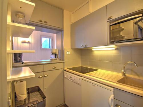 une cuisine avec des armoires blanches et un évier dans l'établissement Appartement 3 pièces avec WiFi et parking, proche centre de Morzine - FR-1-524-135, à Morzine