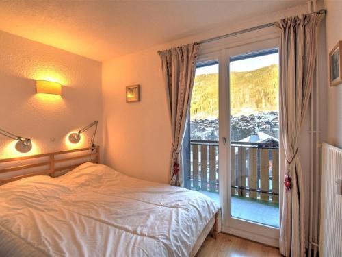 une chambre avec un lit et une grande fenêtre dans l'établissement Appartement 3 pièces avec WiFi et parking, proche centre de Morzine - FR-1-524-135, à Morzine