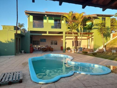 a swimming pool in front of a house at Chácara Buíque&Xique in Jarinu
