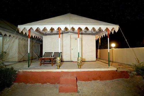 a white tent with a table in it at night at Royal Adventure Jaisalmer Resort in Jaisalmer