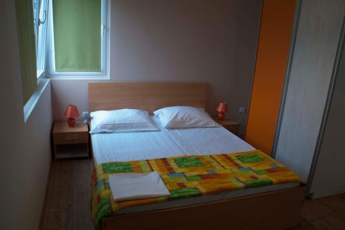 a bedroom with a bed with a colorful quilt on it at Apartments Martina in Bibinje