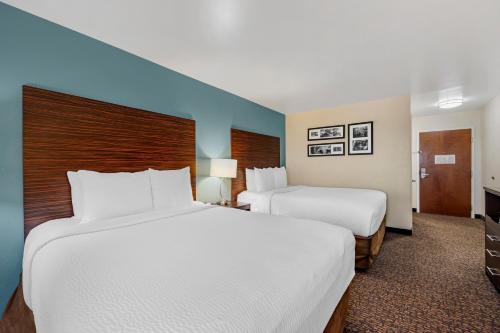 two beds in a hotel room with white sheets at Sleep Inn & Suites Huntsville near US Space & Rocket Center in Huntsville