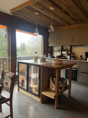 une cuisine avec un îlot en bois au milieu dans l'établissement Confort et Proximité, à Megève