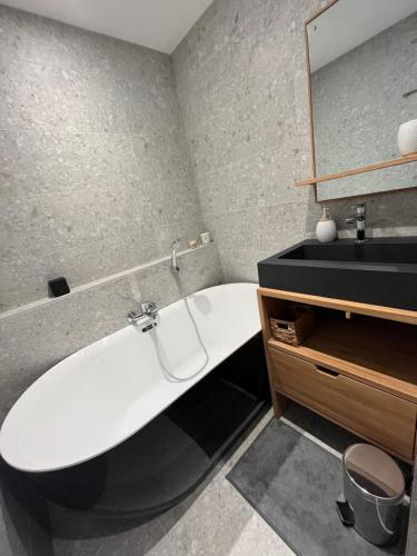 une salle de bain avec une baignoire blanche et un lavabo dans l'établissement Confort et Proximité, à Megève