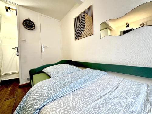- une chambre avec un lit doté d'une tête de lit verte dans l'établissement La Dépendance - studio cosy, à Rouen