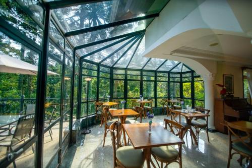 an empty restaurant with tables and chairs and windows at Araucária Lodge - 800 metros do Capivari in Campos do Jordão