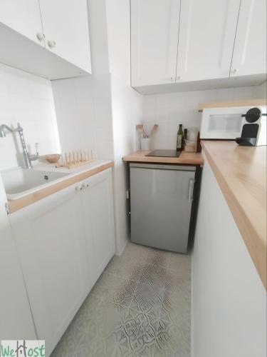 une cuisine blanche avec un évier et un micro-ondes dans l'établissement Paroisse - CI - Versailles Le Cocon, nid douillet à deux pas du Château, à Versailles