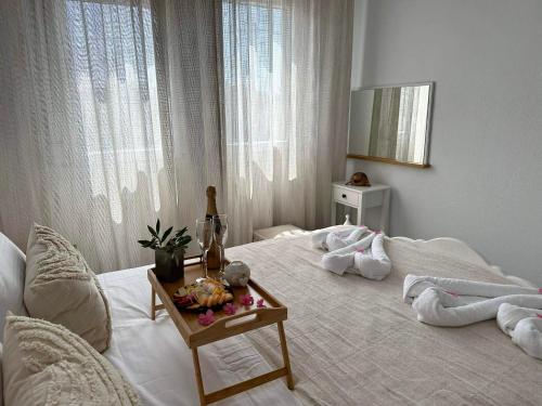a bedroom with a white bed with a table on it at Emerald Luxury Apartments in Limenas