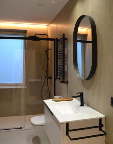 a bathroom with a sink and a mirror at Las Terrazas de Candás in Candás