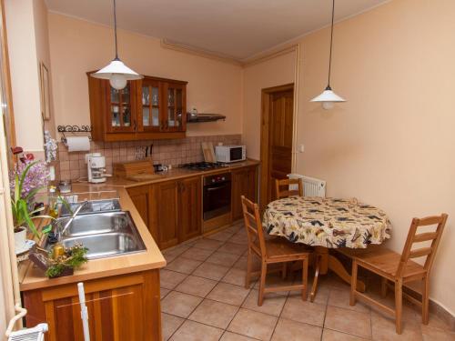 a kitchen with a table and a sink and a table and chairs at Amadeus Vendégház in Esztergom