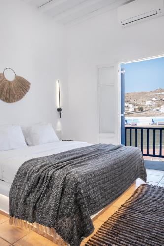 a bedroom with a bed and a large window at Mykonian Style w Shared Pool Houses 8 & 9 in Ornos