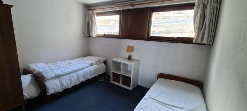 une petite chambre avec deux lits et une fenêtre dans l'établissement Résidence Plein Ciel - maeva Home - Appartement 2 pièces 5 personnes - Confort MAE-1211, à La Mongie