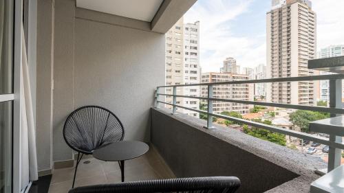 a room with a balcony with a chair and a window at By DH: Luxo e conforto em Perdizes, aos poucos minutos do Allianz parque in Sao Paulo