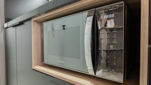 a microwave oven sitting on top of a shelf at By DH: Luxo e conforto em Perdizes, aos poucos minutos do Allianz parque in Sao Paulo