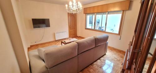 a living room with a couch and a television at Apartamento M in Arteixo